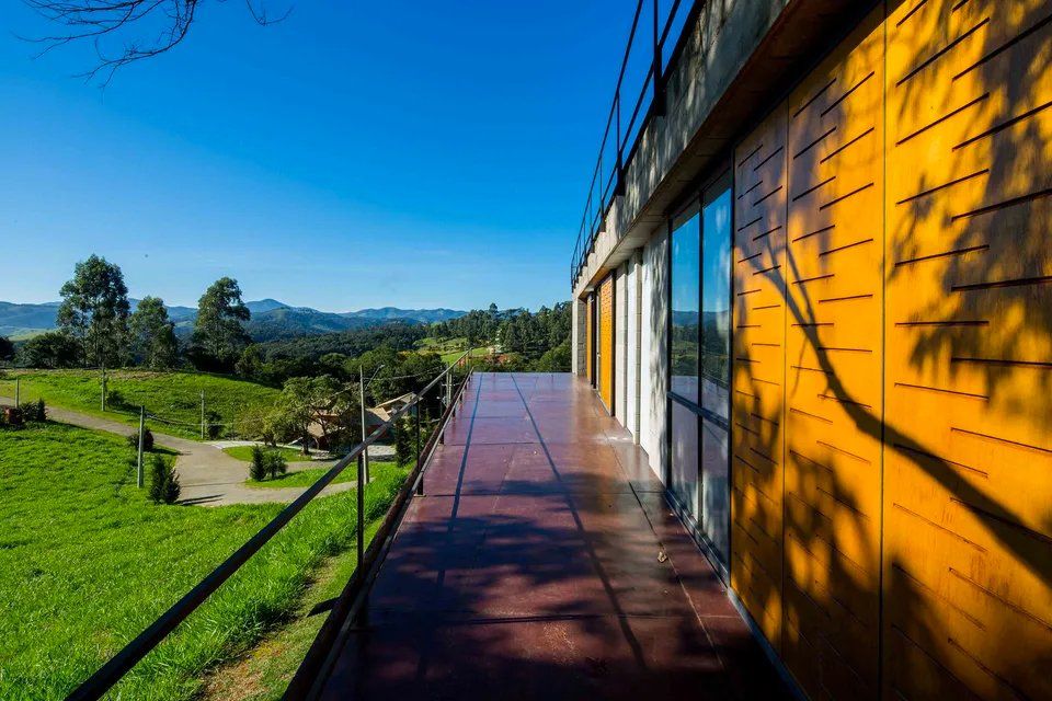 Uma varanda com vista para o campo e para as montanhas.