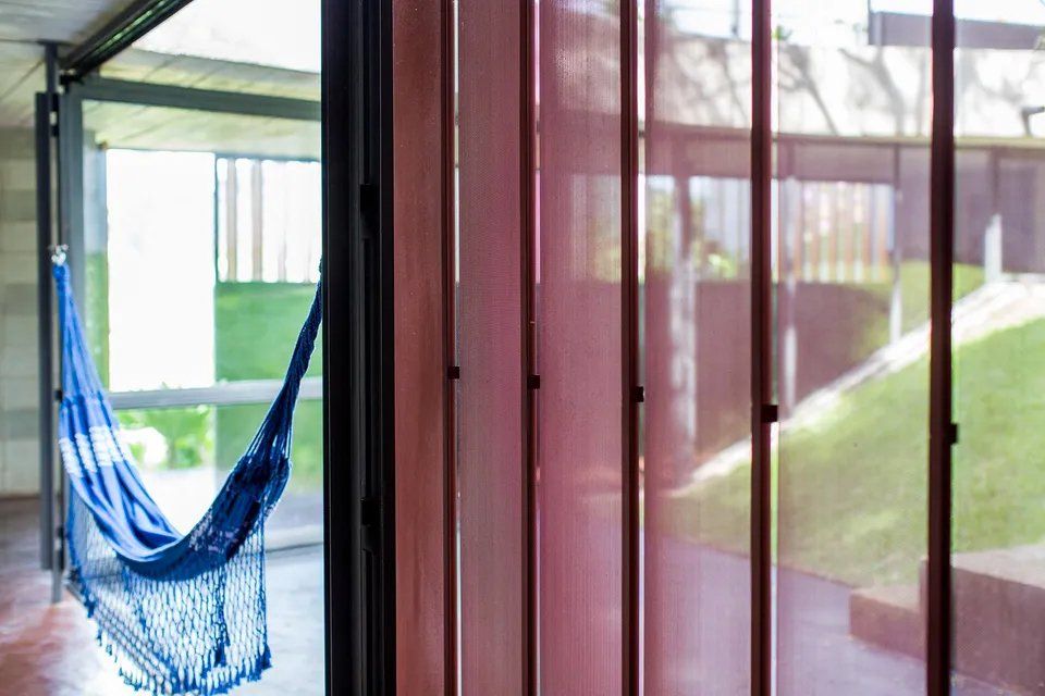 Uma rede azul está pendurada na janela de uma sala.