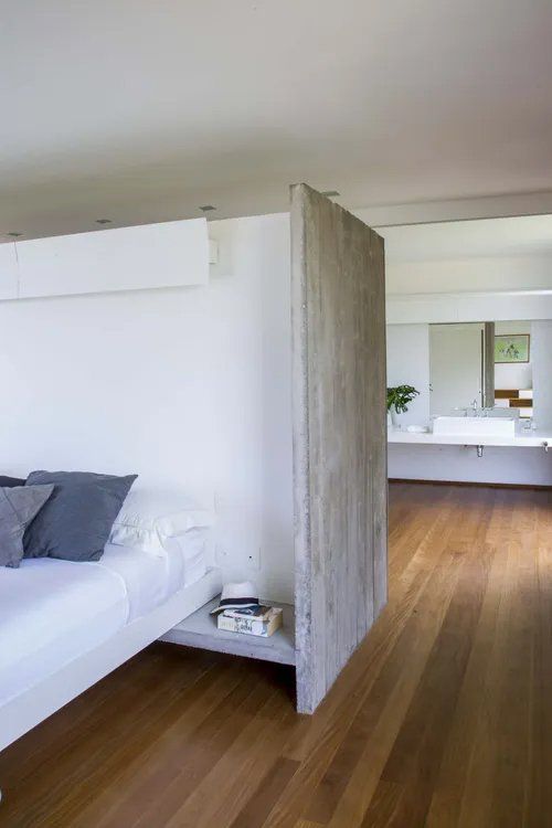 Um quarto com uma cama e piso de madeira