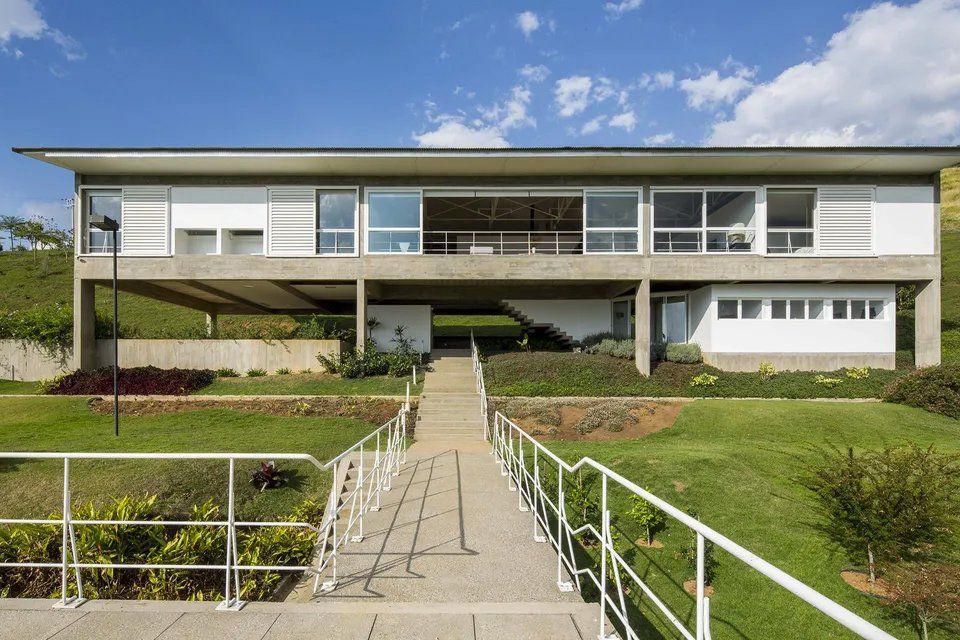 Uma grande casa branca com uma passarela que leva até ela.