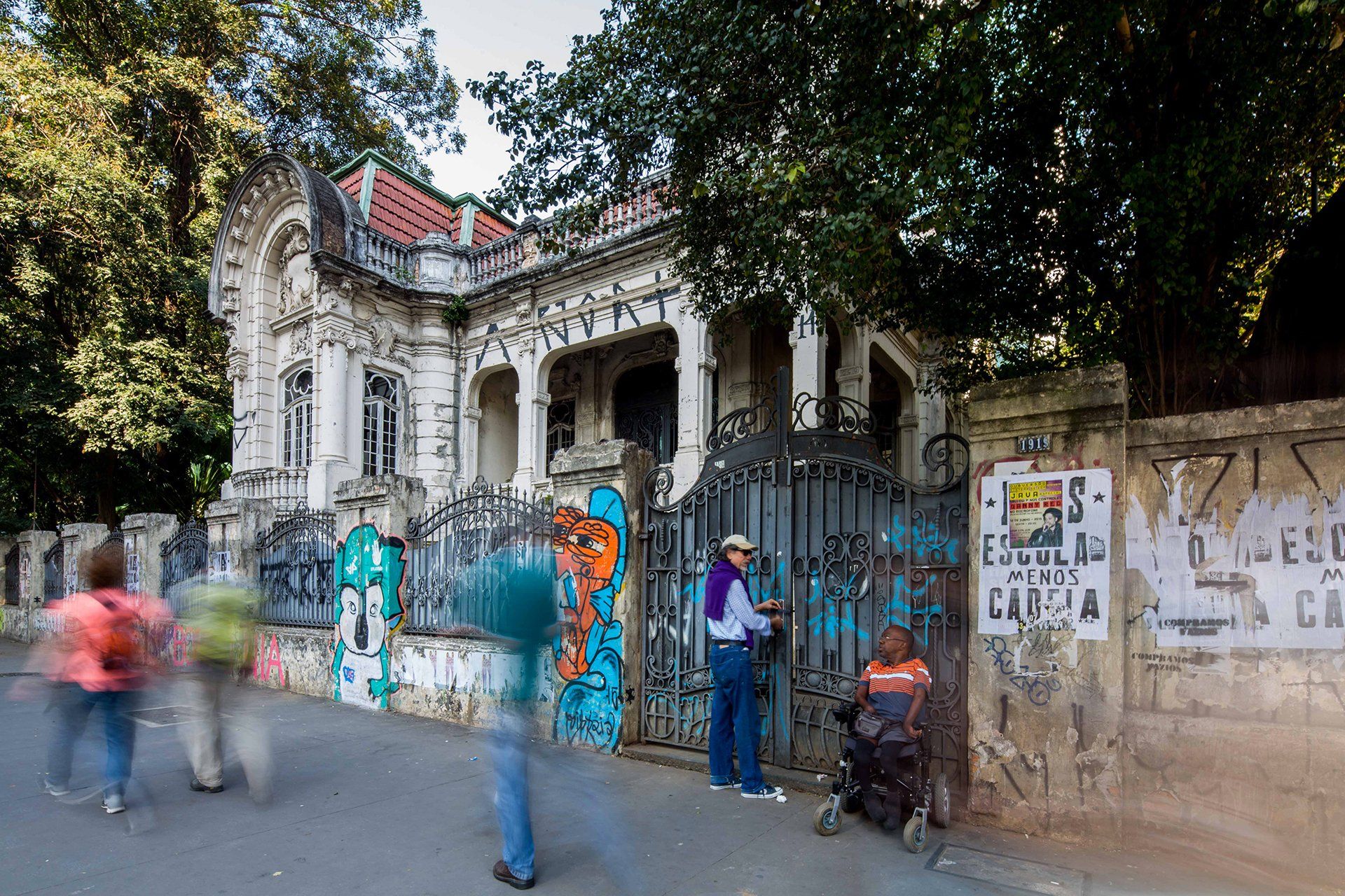 Um homem parado em frente a um prédio com graffiti