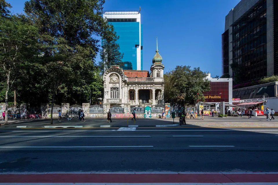 Um grande edifício está situado na esquina de uma rua da cidade.