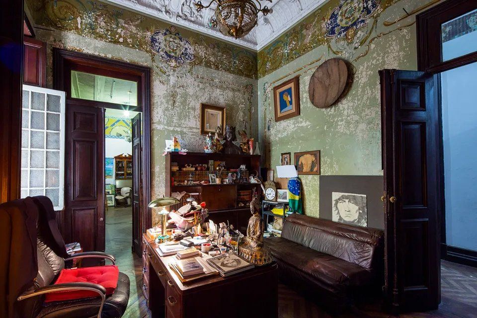 Uma sala de estar com mesa, cadeiras e um banco.