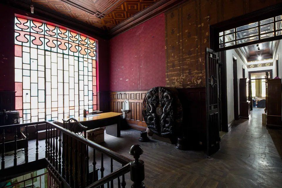 Uma sala com mesa e cadeiras e um vitral.