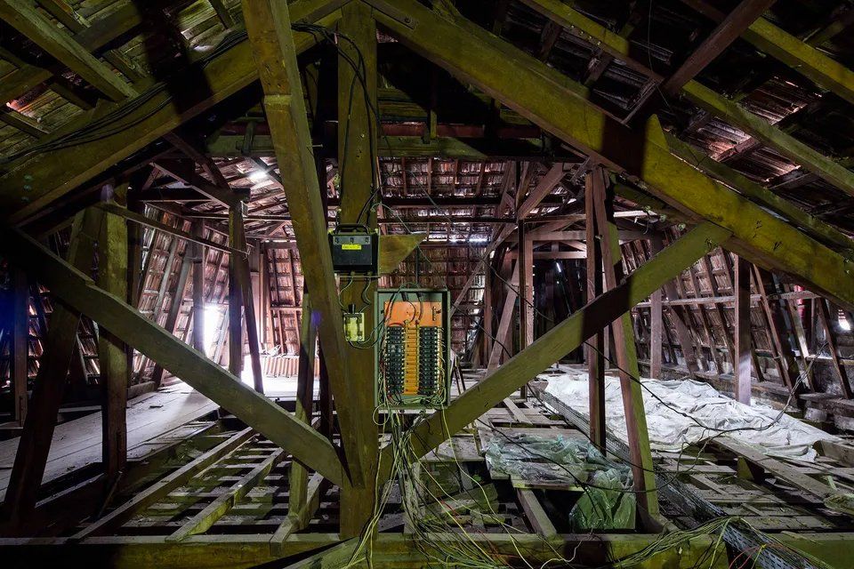 O interior de um edifício antigo com vigas de madeira e telhado.