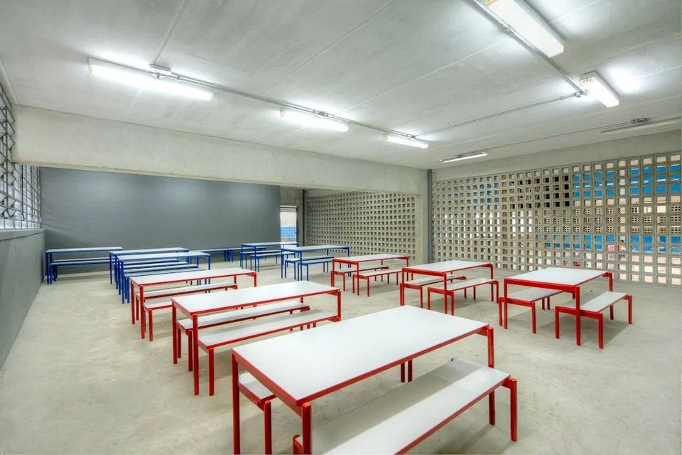 Uma grande sala com mesas e bancos