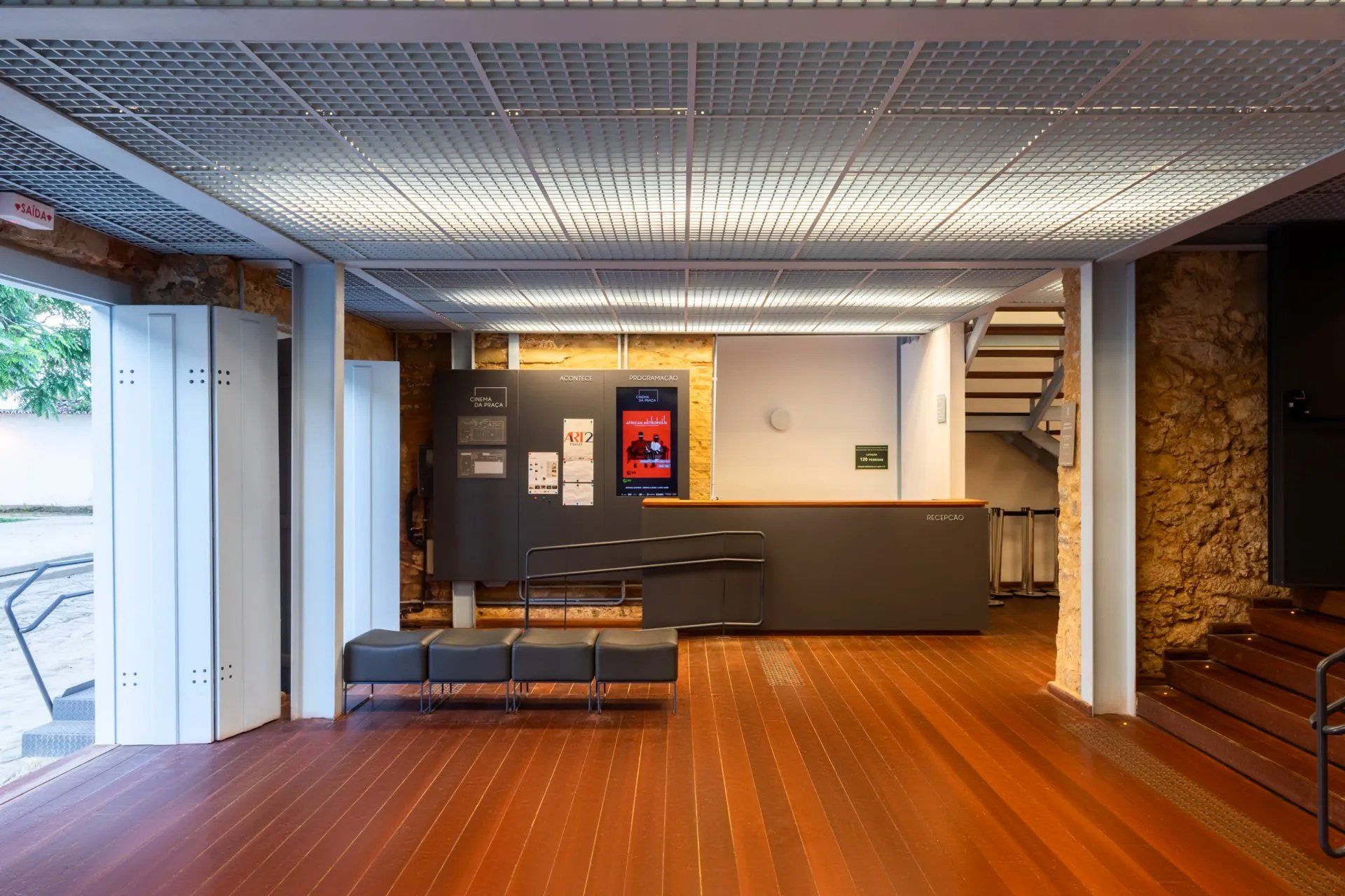 Uma grande sala com piso de madeira e escadas