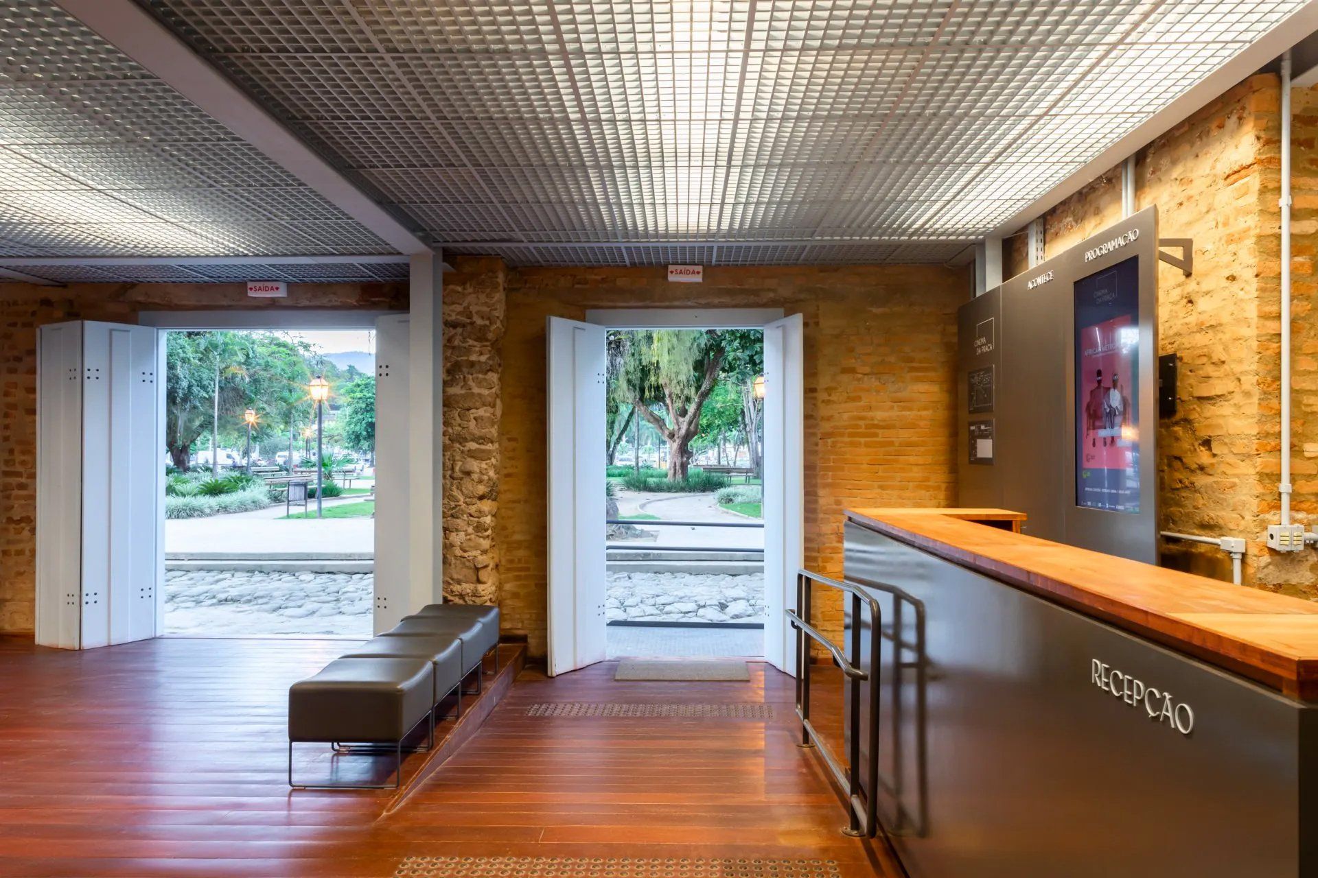 Um hall de entrada com piso de madeira e parede de tijolos.