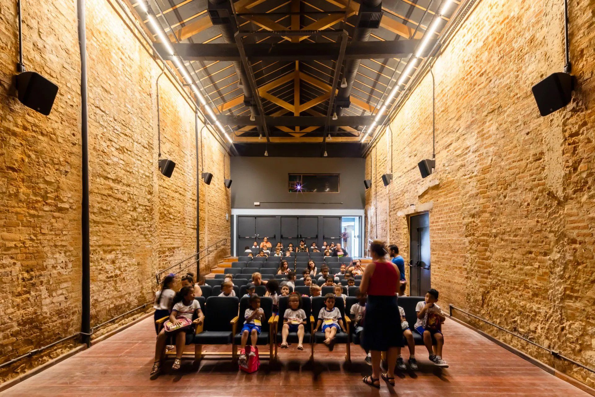 Um grupo de pessoas está sentado em um grande auditório.