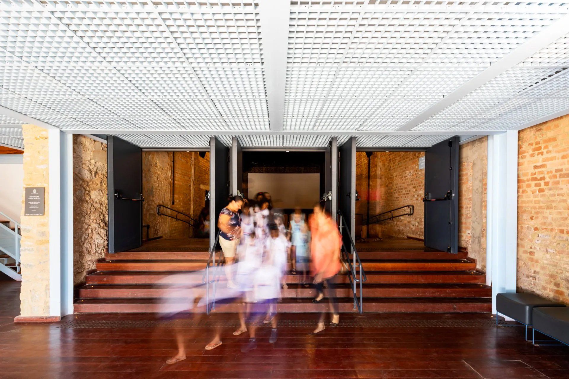 Um grupo de pessoas está descendo as escadas de um prédio.