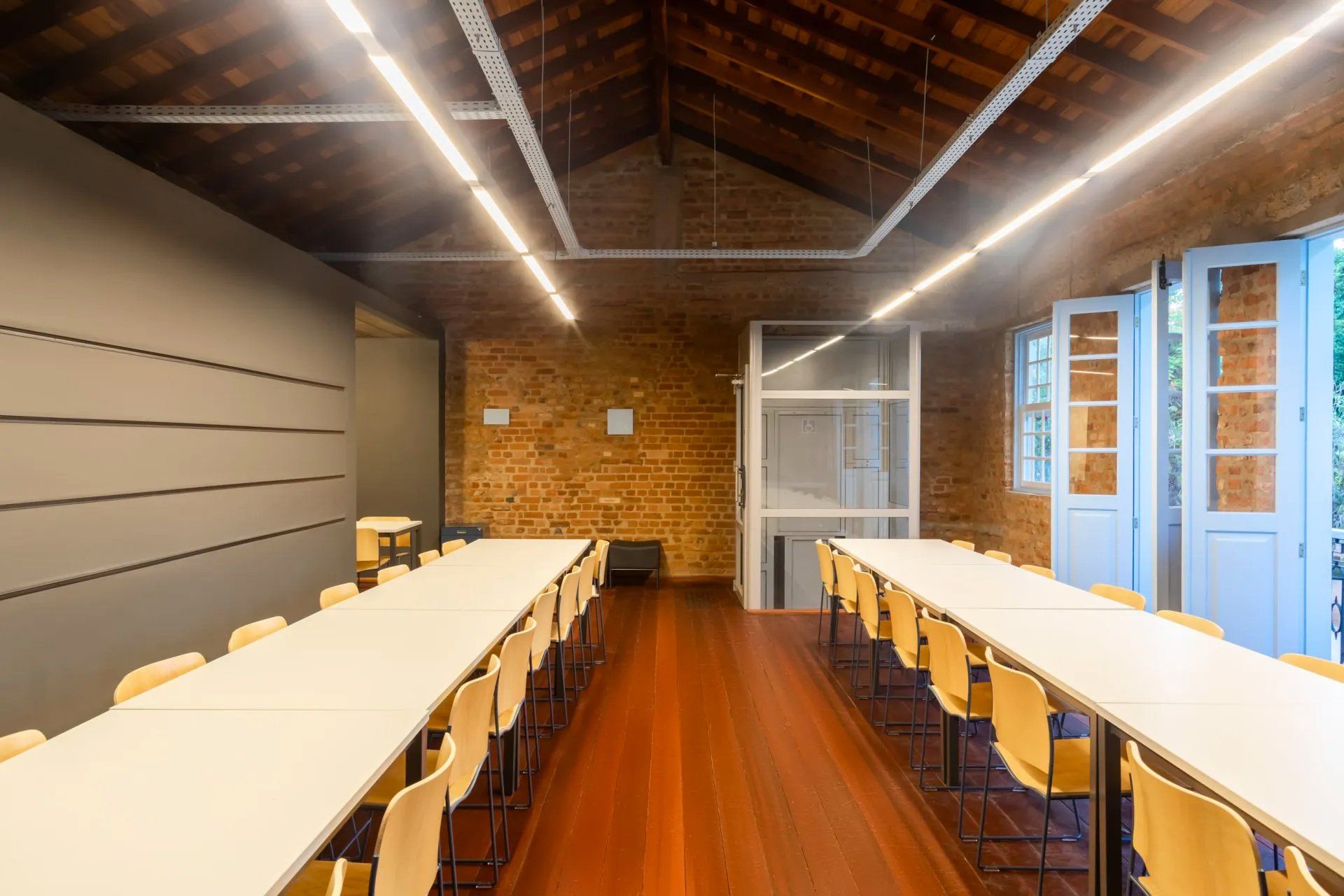 Há muitas mesas e cadeiras nesta sala.