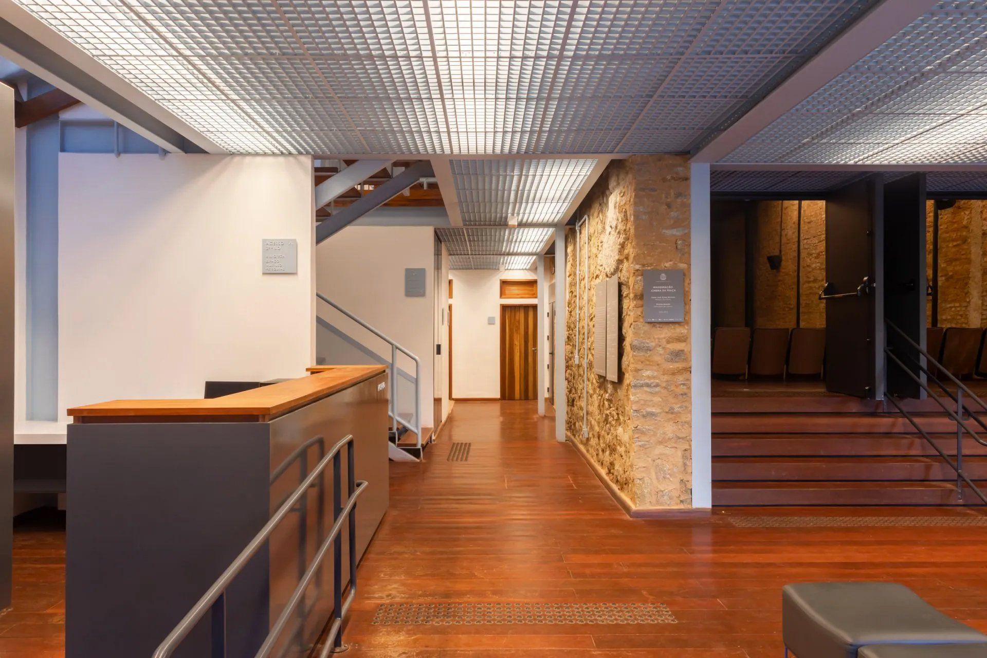 Um longo corredor com piso de madeira e escadas