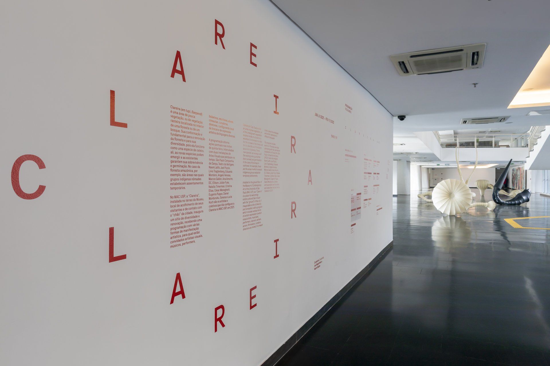 Uma parede branca com letras vermelhas em um corredor.