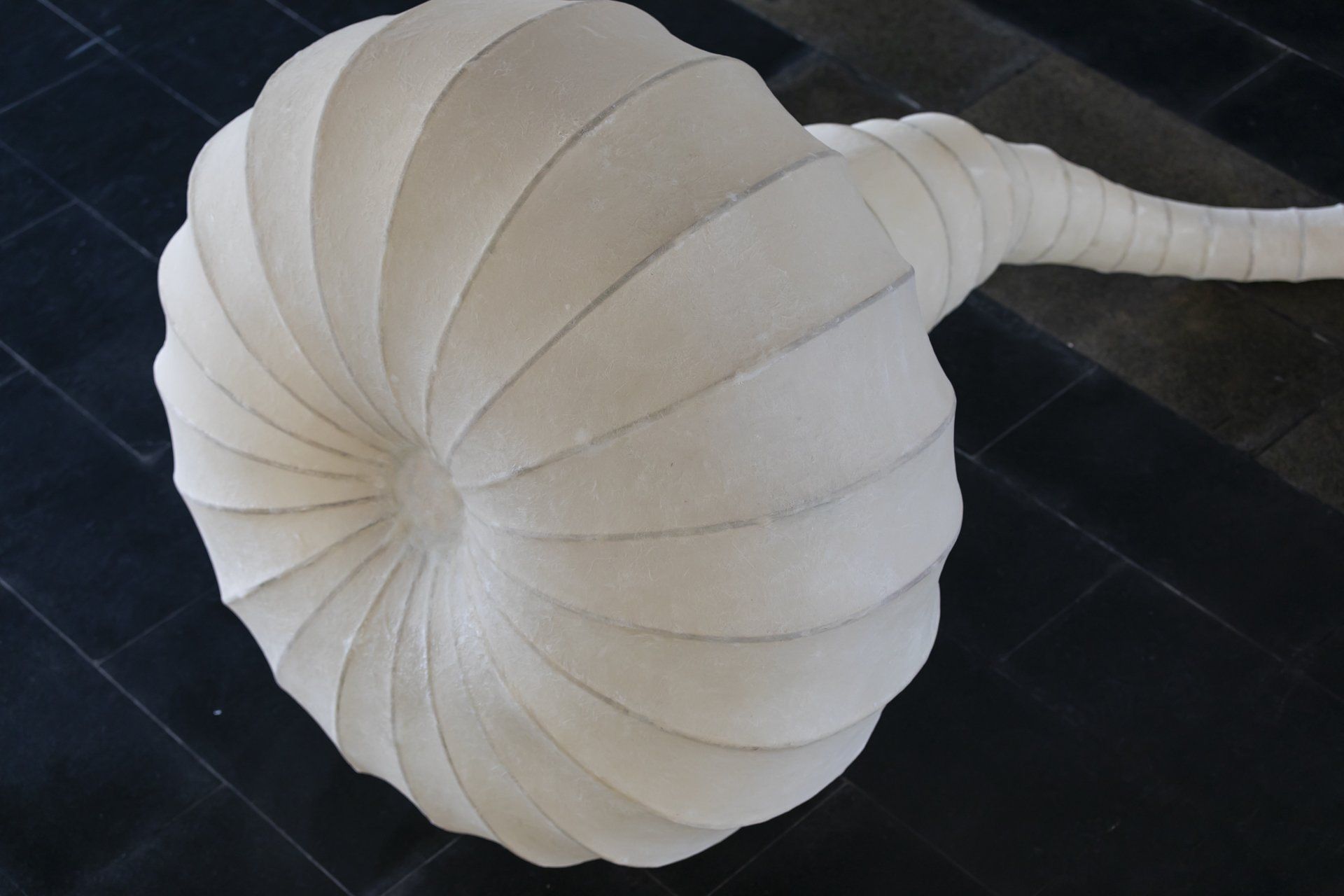 Um grande objeto branco está sobre um chão de azulejos