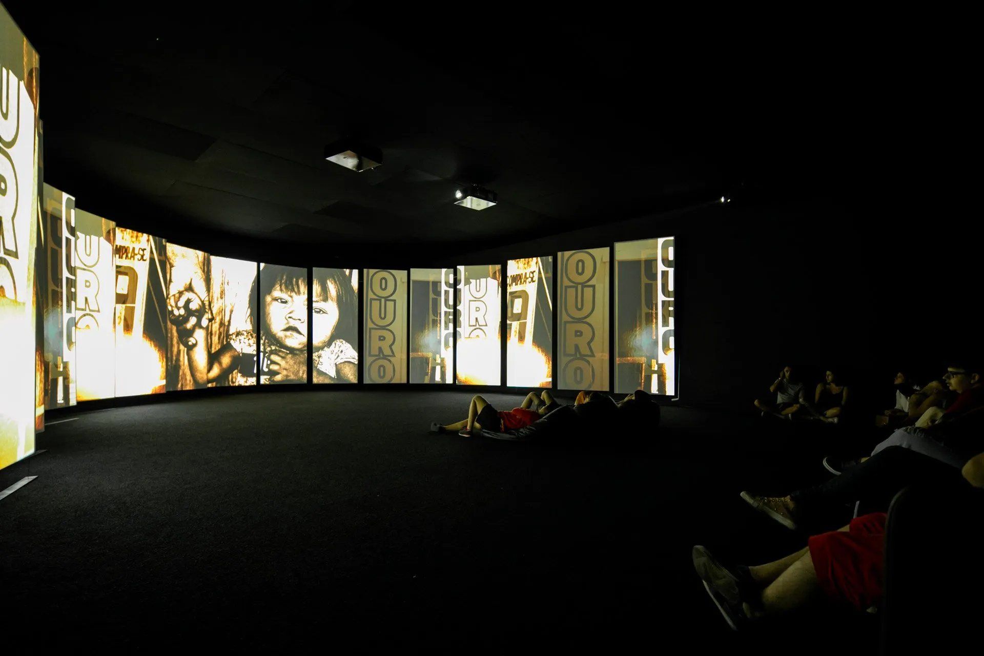 Um grupo de pessoas está assistindo a um filme em um quarto escuro