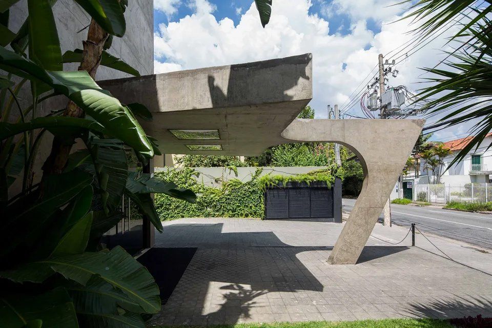 Um edifício com arco de betão que dá acesso a uma garagem.