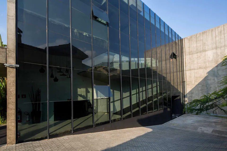 Um grande edifício com muitas janelas e uma parede de concreto.