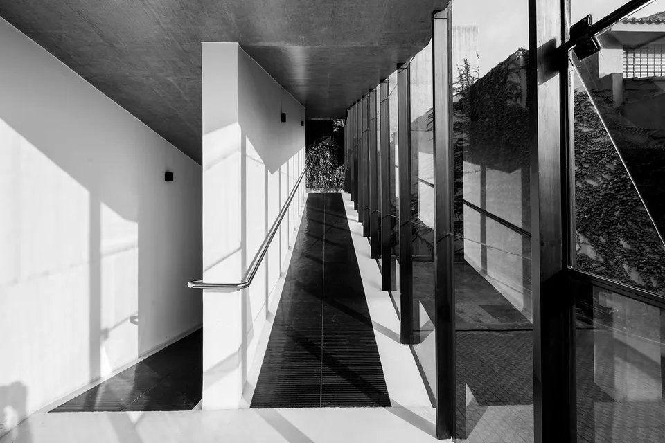 Uma foto em preto e branco de um longo corredor em um prédio