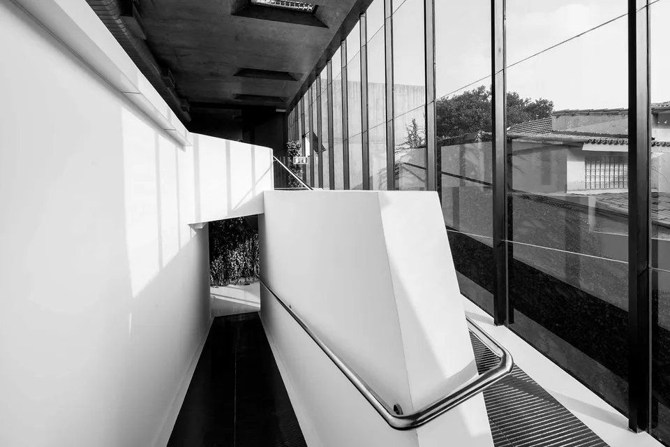 Uma foto em preto e branco de uma escada em um prédio