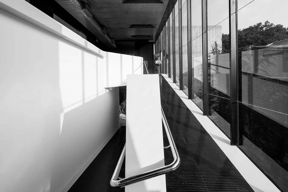 Uma foto em preto e branco de um corredor com grade