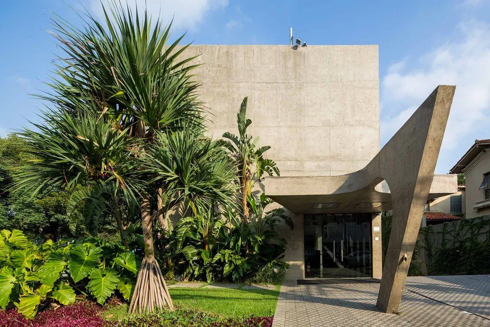 Um grande edifício com muitas árvores na frente.