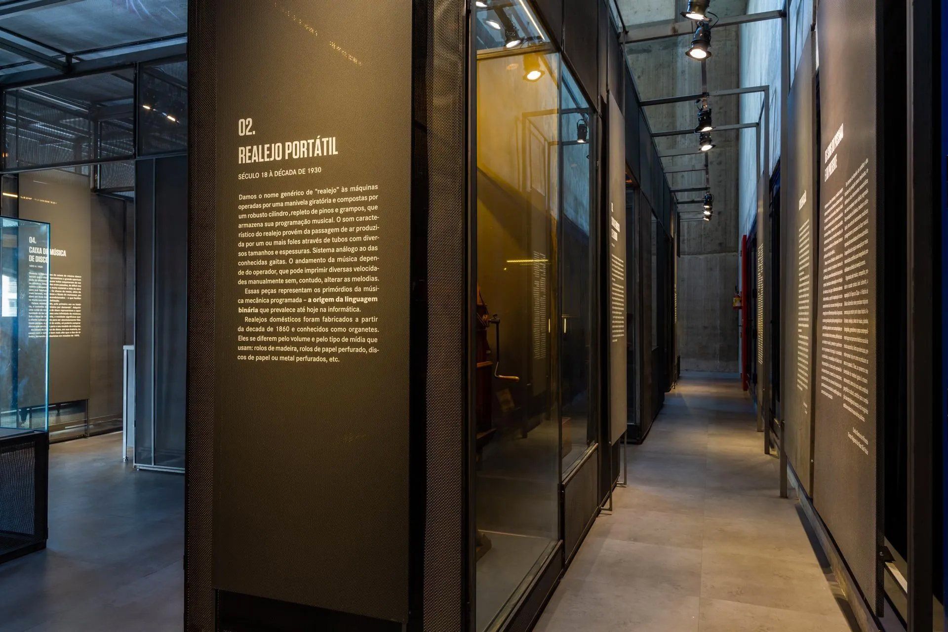 Um longo corredor com muitas janelas e uma placa na parede.