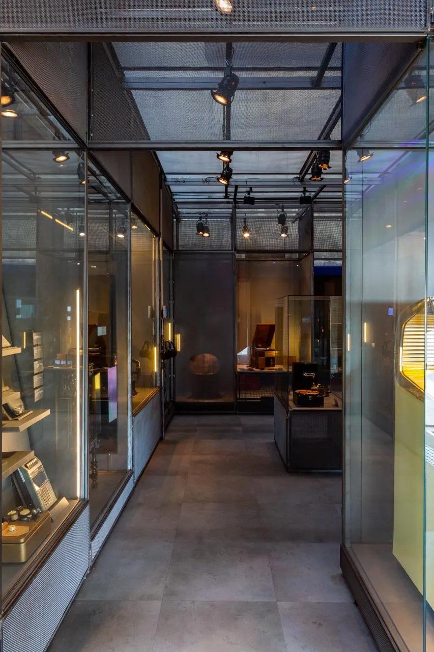 Um longo corredor cheio de paredes de vidro e exposições em um museu.