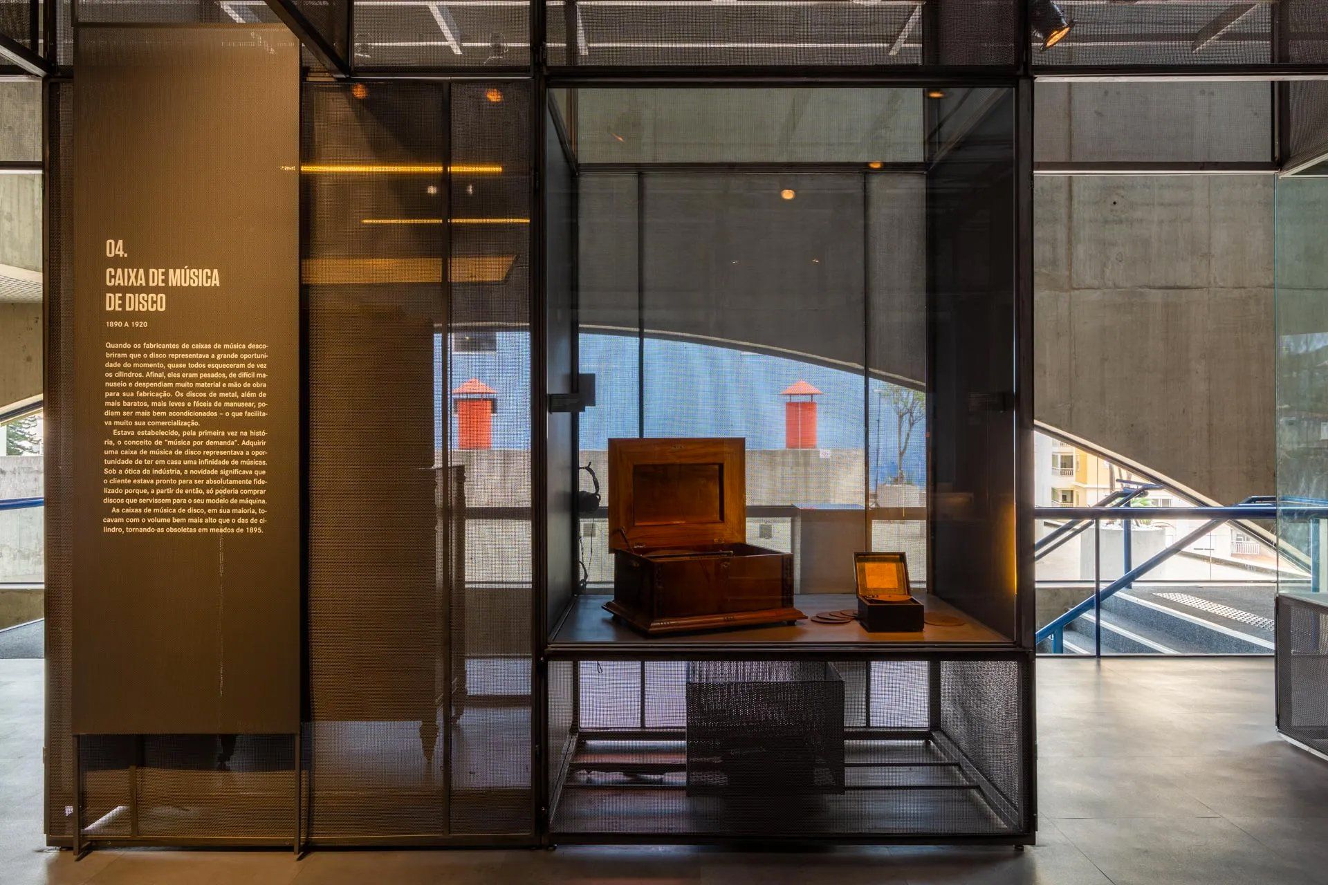 Uma vitrine de vidro com uma caixa de madeira em cima.