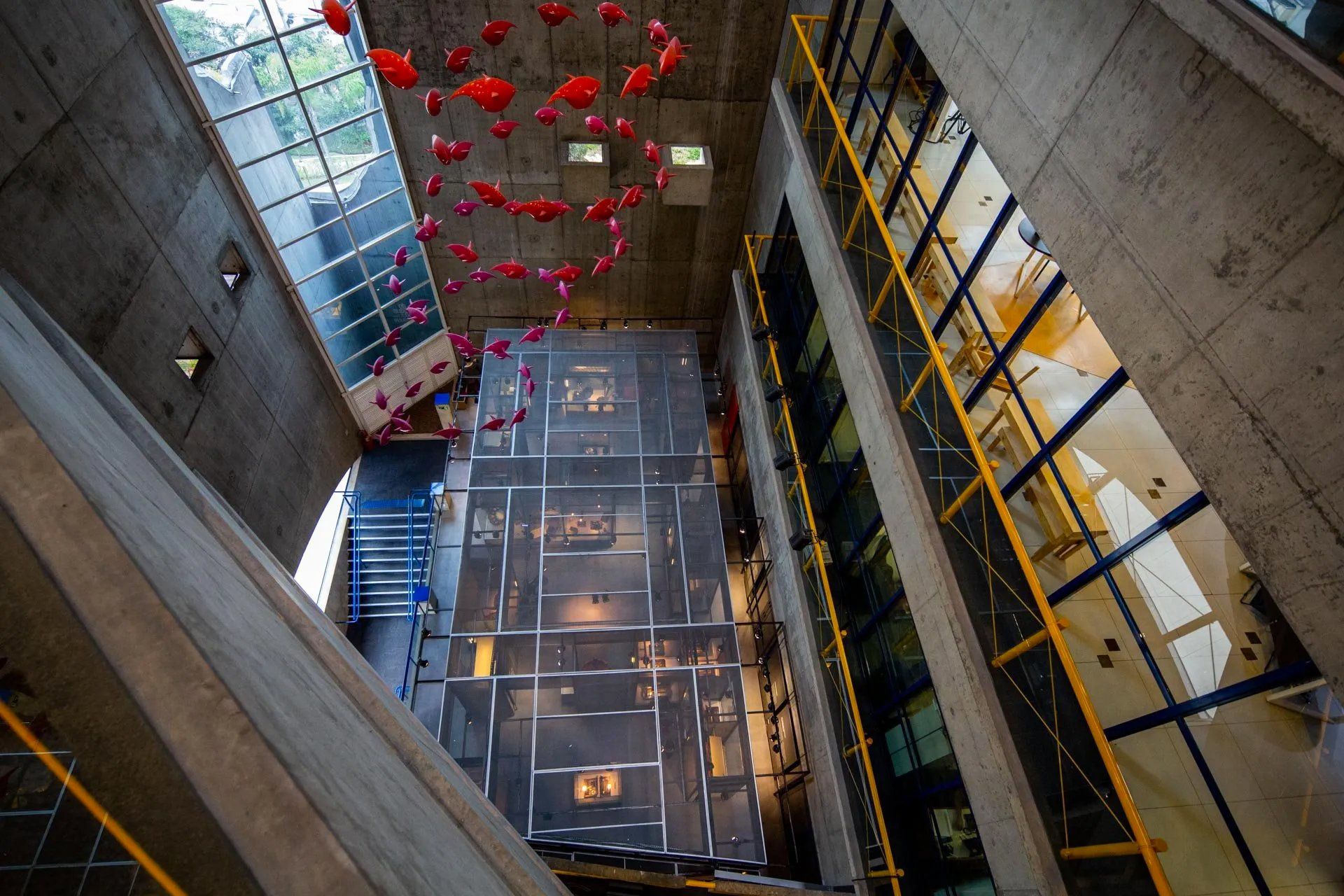 Uma vista aérea de um prédio com muitas janelas e balões vermelhos pendurados no teto.