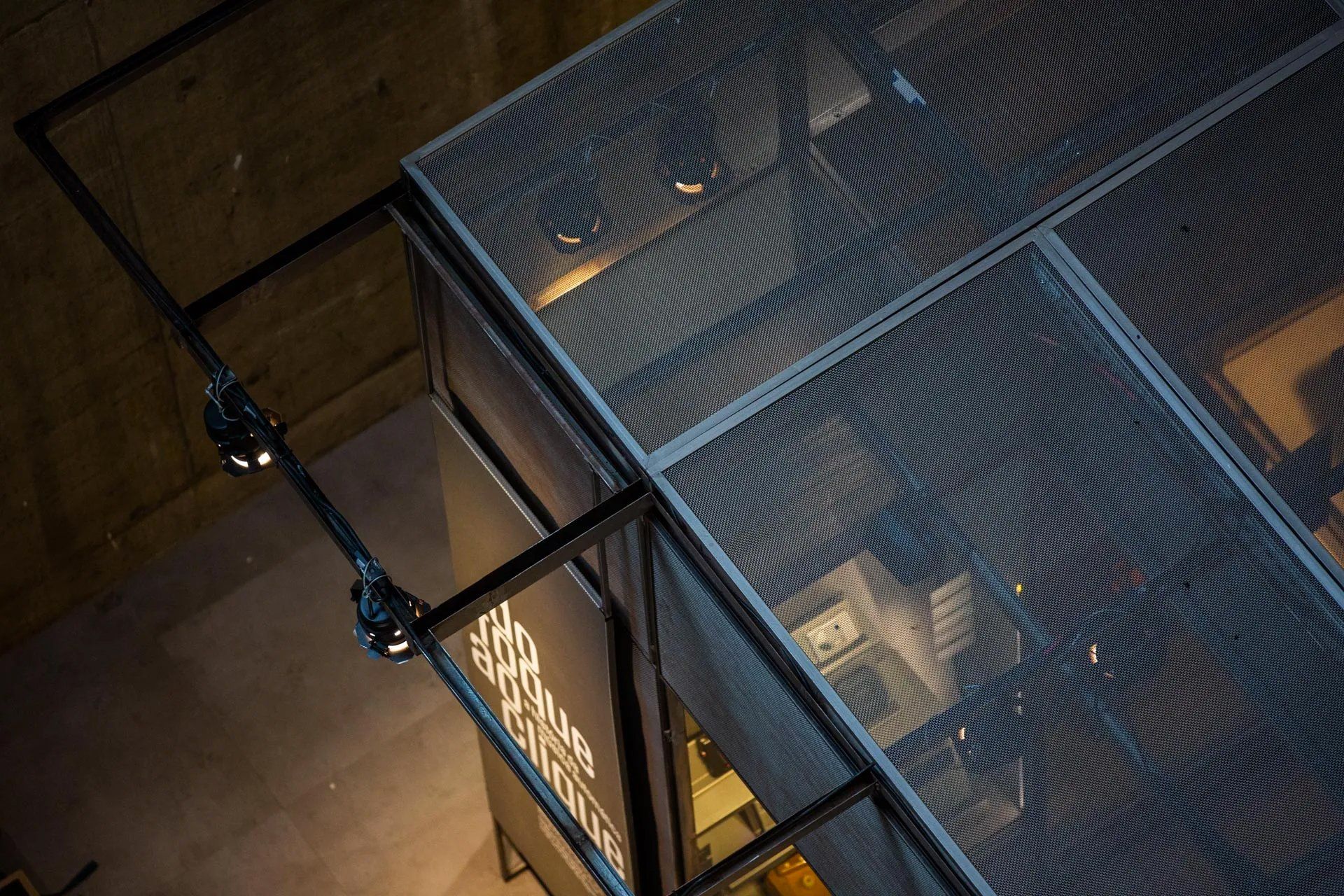 Uma vista aérea de um edifício com telhado de malha metálica.