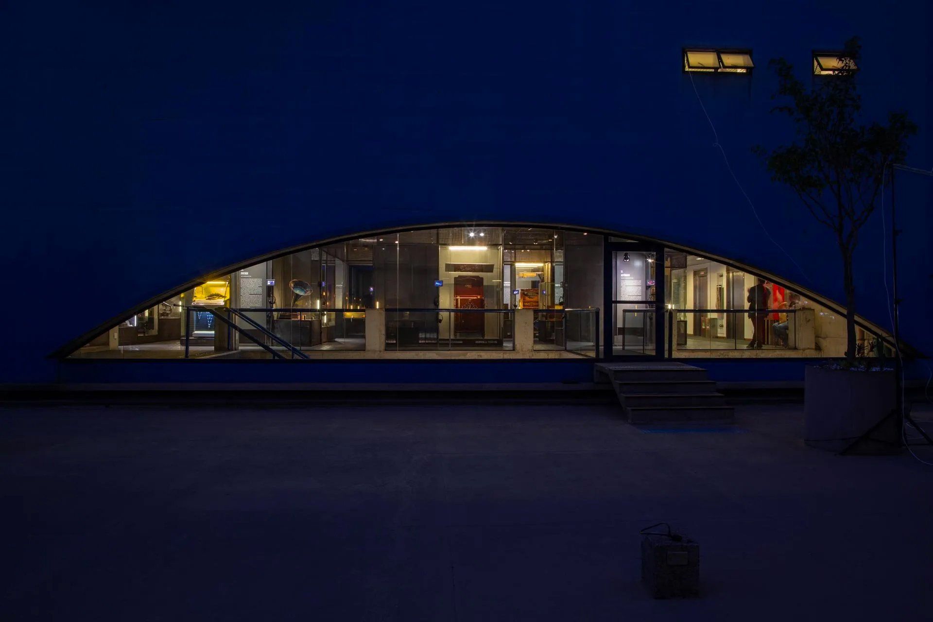 Um prédio com muitas janelas fica iluminado à noite.