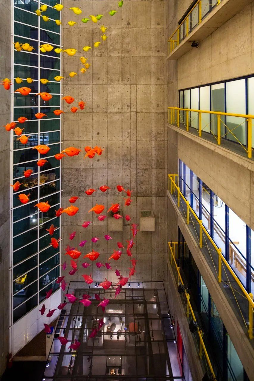 Um monte de peixes está pendurado no teto de um prédio