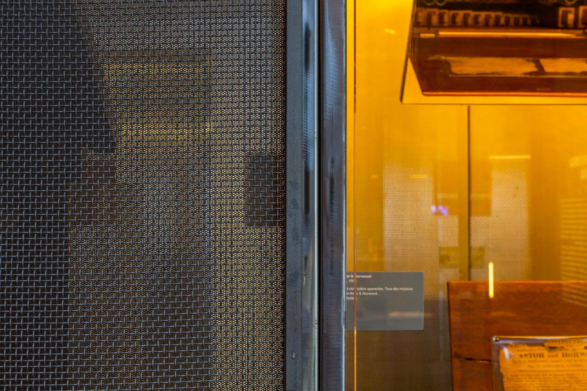 Um close de uma janela com uma parede amarela atrás dela.