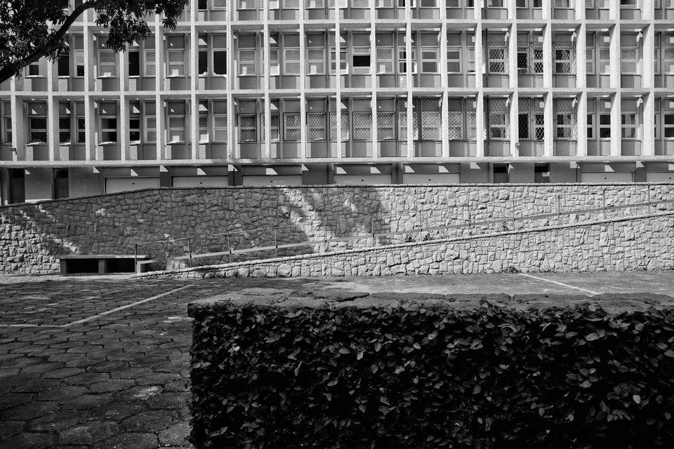 Uma foto em preto e branco de um prédio com uma parede de pedra