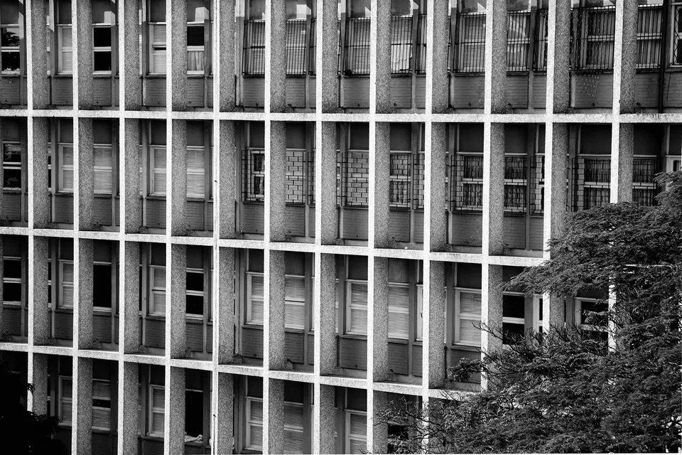 Uma foto em preto e branco de um prédio com muitas janelas.