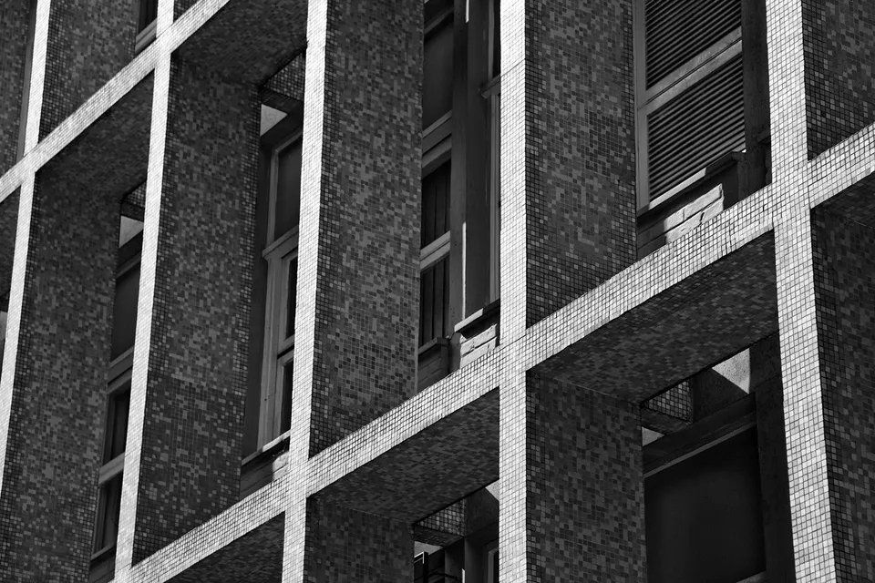 Uma foto em preto e branco de um prédio com muitas janelas.