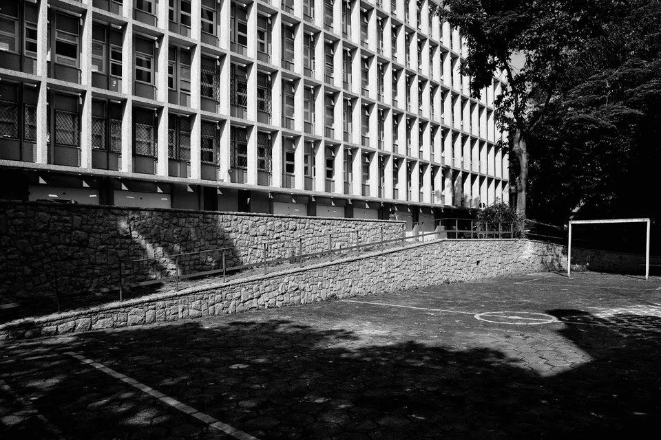 Uma foto em preto e branco de um campo de futebol em frente a um grande edifício