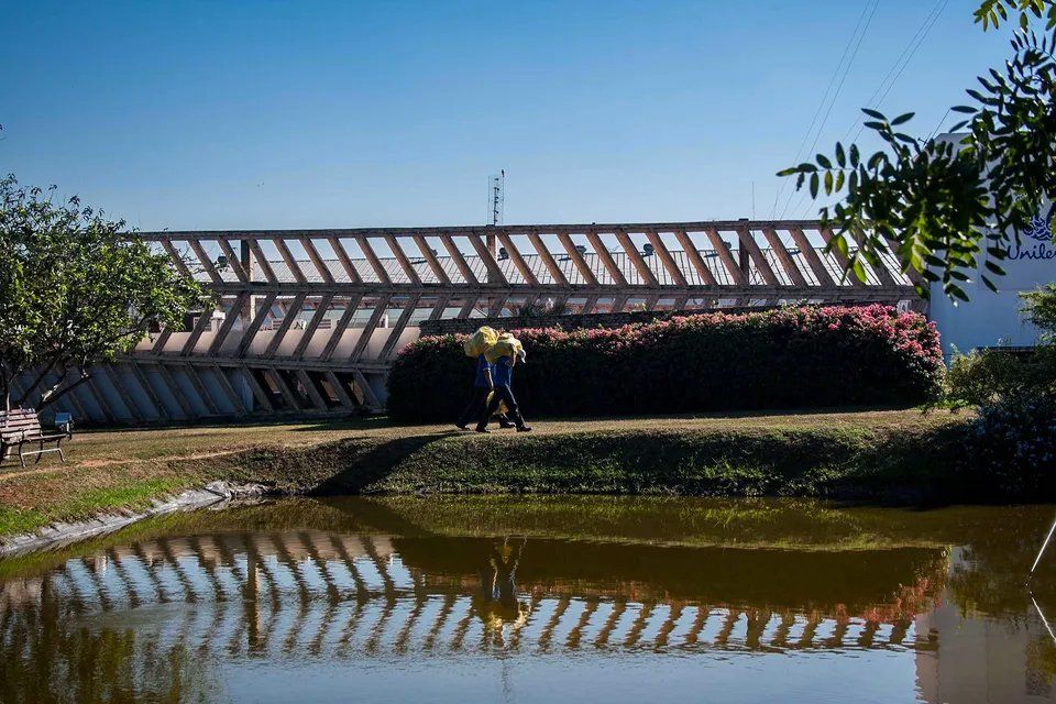 Um casal está atravessando uma ponte sobre um lago.