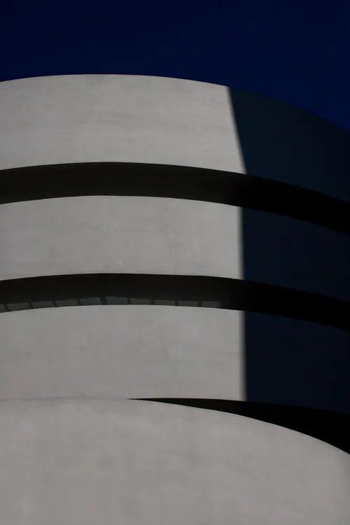 Uma foto em preto e branco de um prédio com um céu azul ao fundo.