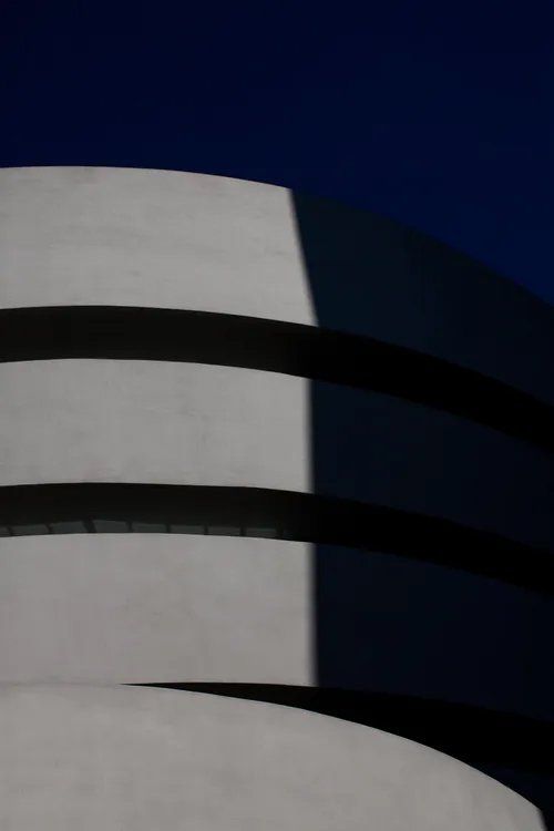 Uma foto em preto e branco de um prédio com um céu azul ao fundo.