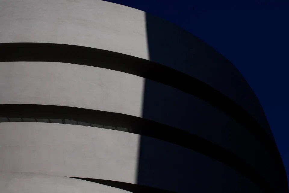 Uma foto em preto e branco de um prédio com um céu azul ao fundo