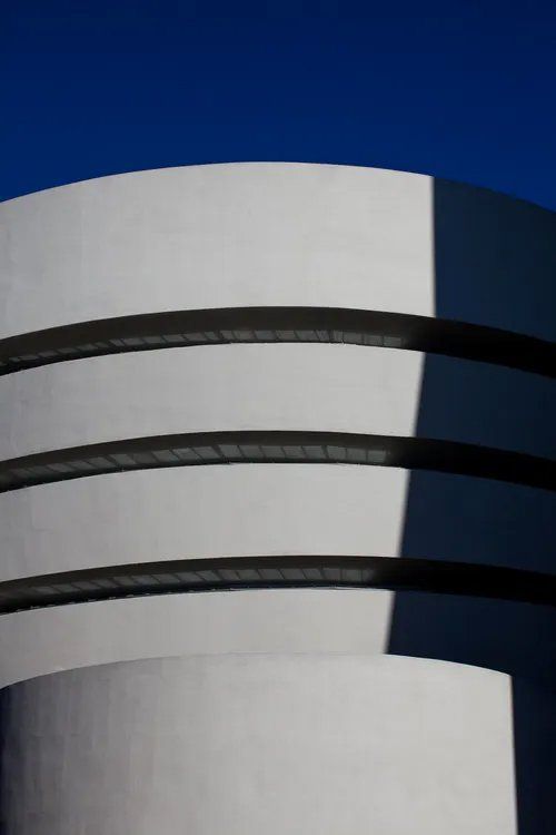 Um prédio branco com um céu azul ao fundo