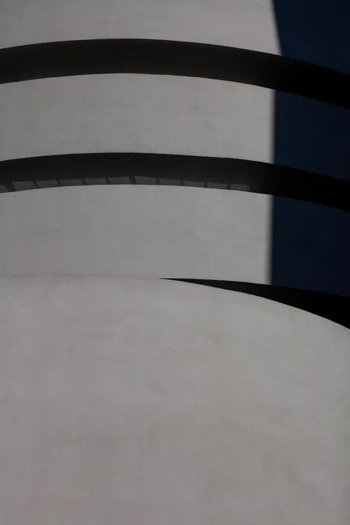 Um close de uma cadeira preta e branca com fundo azul.