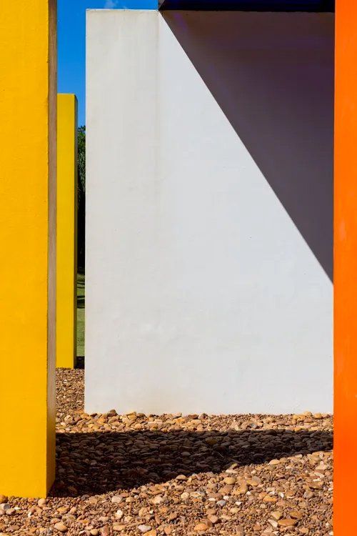 Uma parede branca é cercada por blocos amarelos e laranja