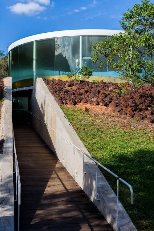 Uma rampa que conduz a um edifício com fachada de vidro.