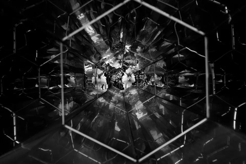 Uma foto em preto e branco de um caleidoscópio em um quarto escuro.