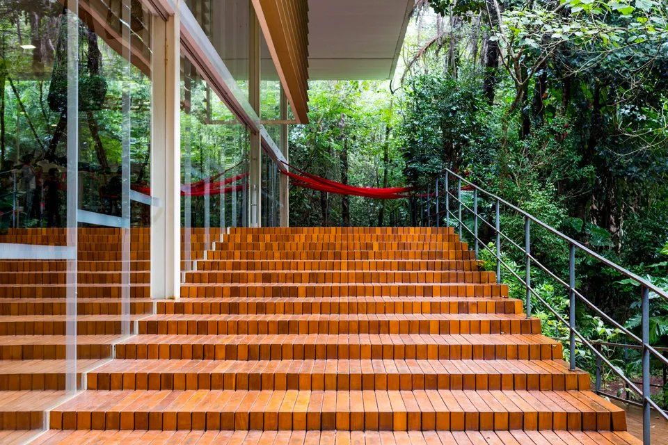 Um lance de escadas que leva até um prédio com uma rede ao fundo.