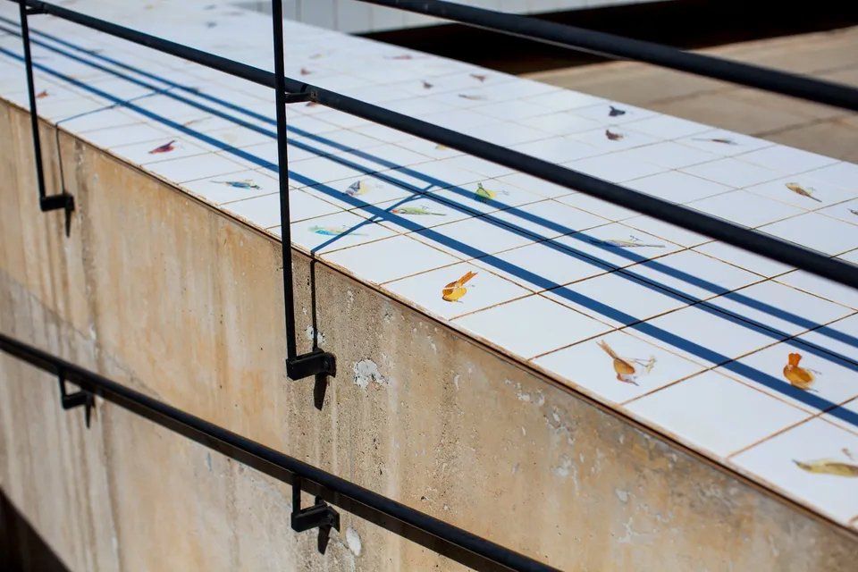 Uma escada com corrimão e azulejos.