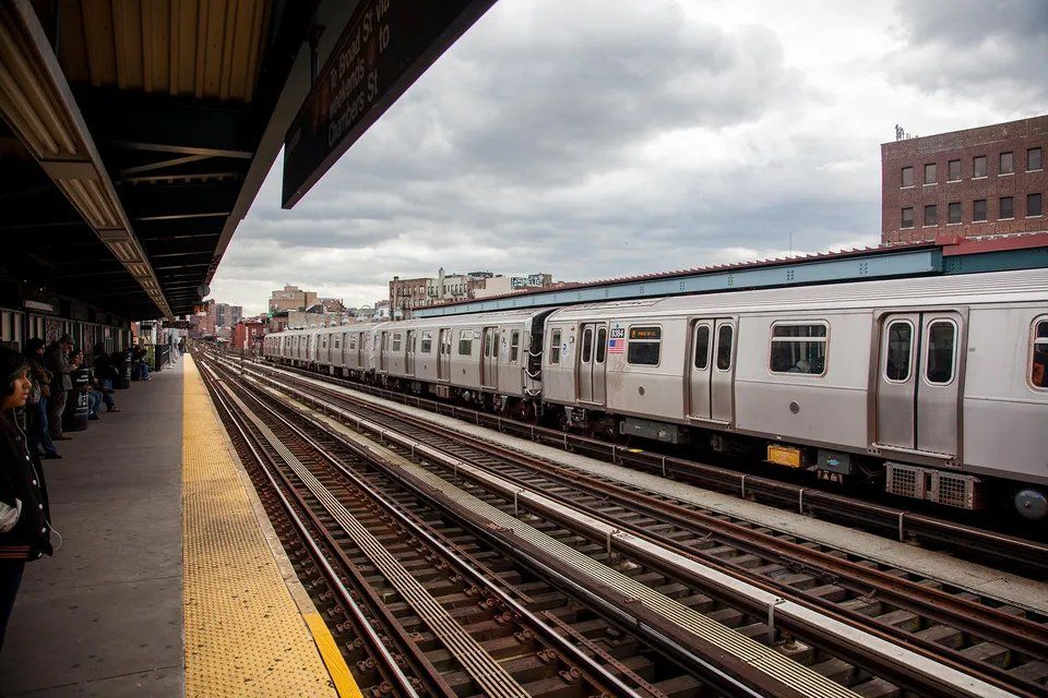 Um trem do metrô está parado nos trilhos de uma estação.