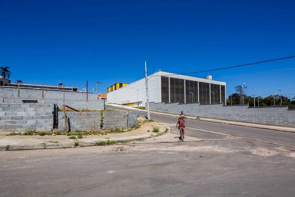 Um homem está andando por uma rua em frente a um prédio.
